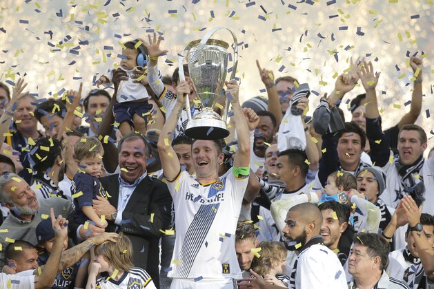 Los Angeles Galaxy's Robbie Keane, center, of Ireland, coach Bruce Arena and teammates celebrate after winning the MLS Cup championship soccer match against the New England Revolution Sunday, Dec. 7, 2014, in Carson, Calif. (AP Photo/Jae C. Hong)