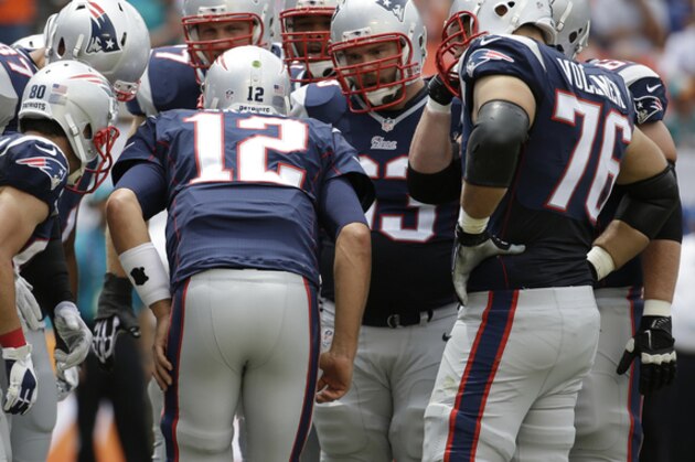 New England Patriots quarterback Tom Brady (12) huddles on the field with the offensive line during the first half of an NFL  football game against the Miami Dolphins, in Miami Garden, Fla., Sunday Sept. 7, 2014. (AP Photo/Lynne Sladky)