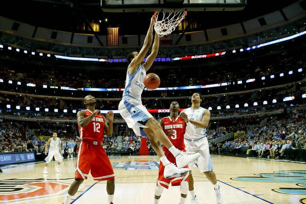 North Carolina forward Brice Johnson (11) dunks as forward Kennedy Meeks (3) and Ohio State forward Sam Thompson (12), guard Shannon Scott (3) look on during the first half of an NCAA college basketball game in CBS Sports Classic on Saturday, Dec. 20, 2014, in Chicago. (AP Photo/Charles Rex Arbogast)