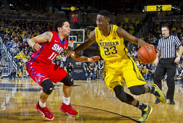 Southern Methodist guard Nic Moore (11) defends Michigan guard Caris LeVert (23) in the second half of an NCAA college basketball game at Crisler Center in Ann Arbor, Mich., Saturday, Dec. 20, 2014. Southern Methodist won 61-51. (AP Photo/Tony Ding)