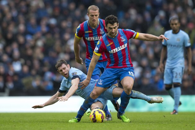 Manchester City's James Milner, bottom, fights for the ball against Crystal Palace's Mile Jedinak, centre, as Brede Hangeland looks on during the English Premier League soccer match between Manchester City and Crystal Palace at the Etihad Stadium, Manchester, England, Saturday Dec. 20, 2014. (AP Photo/Jon Super)