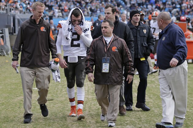 Cleveland Browns' Johnny Manziel (2) is helped off the field after being injured in the first half of an NFL football game against the Carolina Panthers in Charlotte, N.C., Sunday, Dec. 21, 2014. (AP Photo/Chuck Burton)
