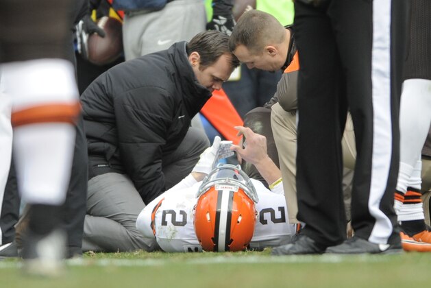 Team members examine Cleveland Browns' Johnny Manziel (2) after Manziel was injured in the first half of an NFL football game against the Carolina Panthers in Charlotte, N.C., Sunday, Dec. 21, 2014. (AP Photo/Mike McCarn)