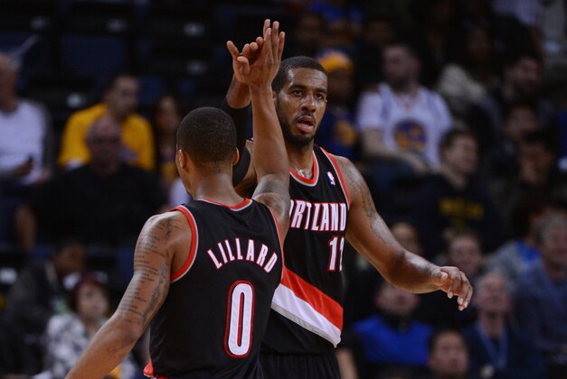 November 23, 2013; Oakland, CA, USA; Portland Trail Blazers power forward LaMarcus Aldridge (12, right) celebrates with point guard Damian Lillard (0) against the Golden State Warriors during the fourth quarter at Oracle Arena. The Trail Blazers defeated the Warriors 113-101. Mandatory Credit: Kyle Terada-USA TODAY Sports