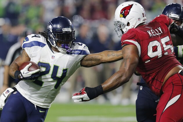 Seattle Seahawks running back Marshawn Lynch (24) fights through Arizona Cardinals defensive end Tommy Kelly (95) on his touchdown run during the first half of an NFL football game, Sunday, Dec. 21, 2014, in Glendale, Ariz. (AP Photo/Rick Scuteri)