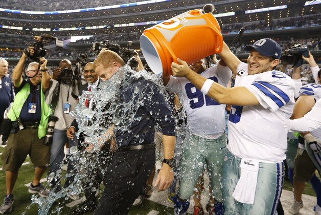 Dec 21, 2014; Arlington, TX, USA; Dallas Cowboys quarterback Tony Romo (9) dunks head coach Jason Garrett with Gatorade after the game against the Indianapolis Colts at AT&T Stadium. The Cowboys beat the Colts 42-7. Mandatory Credit: Matthew Emmons-USA TODAY Sports