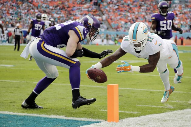Miami Dolphins wide receiver Mike Wallace (11) scores a touchdown as Minnesota Vikings free safety Harrison Smith (22) is late with the tackle during the second half of an NFL football game, Sunday, Dec. 21, 2014, in Miami Gardens, Fla. (AP Photo/Lynne Sladky)