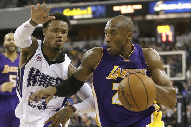 Los Angeles Lakers guard Kobe Bryant, right, drives to the basket against Sacramento Kings guard Ben McLemore during the first half of an NBA basketball game in Sacramento, Calif., Sunday, Dec. 21, 2014. (AP Photo/Rich Pedroncelli)