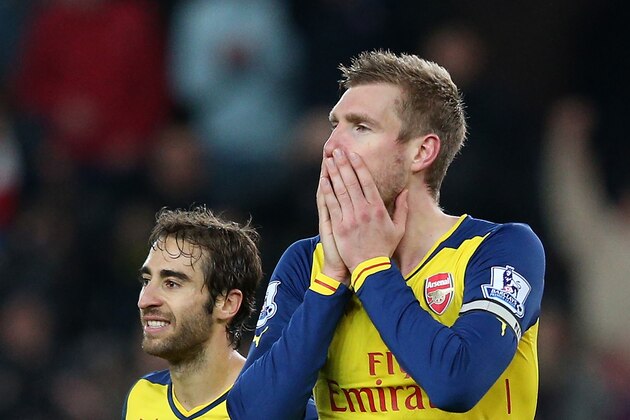 STOKE ON TRENT, ENGLAND - DECEMBER 06:  Mathieu Flamini (L) and Per Mertesacker of Arsenal react after Calum Chambers of Arsenal is shown a red card by Referee Anthony Taylor during the Barclays Premier League match between Stoke City and Arsenal  at the Britannia Stadium on December 6, 2014 in Stoke on Trent, England.  (Photo by Clive Mason/Getty Images)