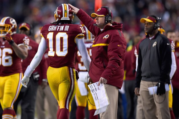LANDOVER, MD - DECEMBER 20:  Quarterback Robert Griffin III #10 of the Washington Redskins passes head coach Jay Gruden as he heads off the field in the first half of a game against the Philadelphia Eagles at FedExField on December 20, 2014 in Landover, Maryland.  (Photo by Patrick Smith/Getty Images)