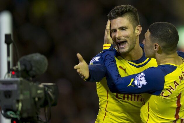 Arsenal's Olivier Giroud, left, blows a kiss to a television camera as he celebrates with teammate Calum Chambers after scoring during the English Premier League soccer match between Liverpool and Arsenal at Anfield Stadium, Liverpool, England, Sunday Dec. 21, 2014. (AP Photo/Jon Super)