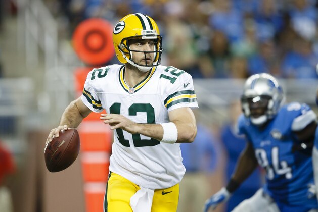 Green Bay Packers quarterback Aaron Rodgers (12) rolls out to pass against the Detroit Lions during an NFL football game at Ford Field in Detroit, Sunday, Sept. 21, 2014. (AP Photo/Rick Osentoski)