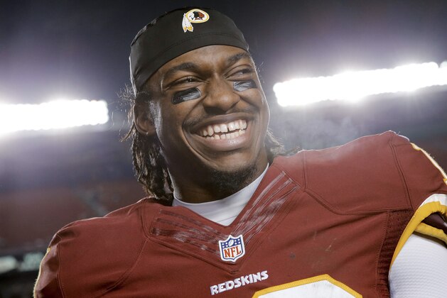 Washington Redskins quarterback Robert Griffin III smiles on the sideline after the Redskins defeated the Philadelphia Eagles 27-24 in an NFL football game Saturday, Dec. 20, 2014, in Landover, Md. (AP Photo/Patrick Semansky)