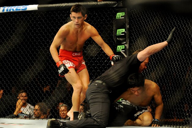 Sep 27, 2014; Las Vegas, NV, USA; The referee calls off the fight after Dominick Cruz (red gloves) knocks out Takeya Mizugaki (blue gloves) during the first round of a bantamweight fight in UFC 178 at MGM Grand Garden Arena. Mandatory Credit: Stephen R. Sylvanie-USA TODAY Sports
