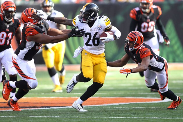 CINCINNATI, OH - DECEMBER 7:  Le'Veon Bell #26 of the Pittsburgh Steelers stiff arms Vincent Rey #57 of the Cincinnati Bengals as Leon Hall #29 of the Cincinnati Bengals dives in an attempt to make the tackle during the second quarter at Paul Brown Stadium on December 7, 2014 in Cincinnati, Ohio. (Photo by John Grieshop/Getty Images)
