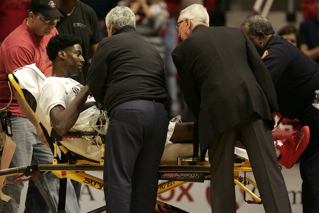 SAN DIEGO, CA - DECEMBER 22:  Dwayne Polee #5  of the San Diego State Aztecs talks with Head coach Steve Fisher, right,  as he is wheeled off the court on a stretcher after collapsing during play in the first half of the game against the UC Riverside Highlanders at Viejas Arena on December 22, 2014 in San Diego, California. (Photo by Kent C. Horner/Getty Images)