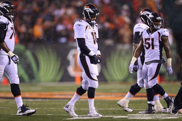 CINCINNATI, OH - DECEMBER 22:  Peyton Manning #18 of the Denver Broncos walks off of the field after throwing an interception to Dre Kirkpatrick #27 of the Cincinnati Bengals during the fourth quarter at Paul Brown Stadium on December 22, 2014 in Cincinnati, Ohio. Cincinnati defeated Denver 37-28. (Photo by Andy Lyons/Getty Images)
