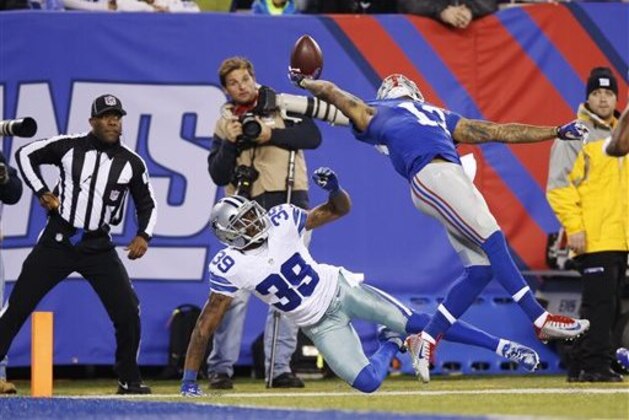 FILE - In this Nov. 23, 2014, file photo, New York Giants wide receiver Odell Beckham Jr. (13) makes a one-handed catch for a touchdown against Dallas Cowboys cornerback Brandon Carr (39) in the second quarter of an NFL football game in East Rutherford, N.J. The one-handed catch by Odell Beckham Jr. that became the most talked-about play from Sunday did more than just boost his standing with the New York Giants, it paid off a routine growing popular among many skill players of practicing the impractical, one-handed circus grab.  (AP Photo/Kathy Willens, File)