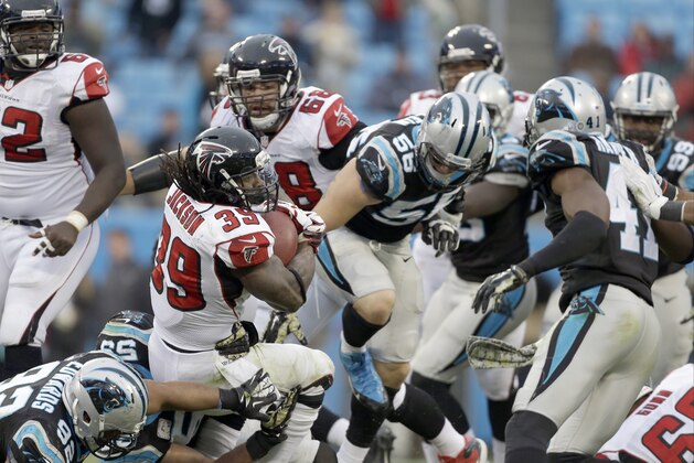 Atlanta Falcons' Steven Jackson (39) protects the football as he pushes his way through the Carolina Panthers' defense during the second half of an NFL football game in Charlotte, N.C., Sunday, Nov. 16, 2014. The Falcons won 19-17. (AP Photo/Bob Leverone)
