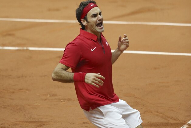 Switzerland's Roger Federer falls to the clay after defeating France Richard Gasquet to win the Davis Cup final between France and Switzerland at Stade Pierre Mauroy in Lille, northern France, Sunday, Nov. 23, 2014. (AP Photo/Peter Dejong)