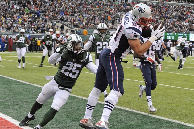 New England Patriots tight end Rob Gronkowski (87) scores a touchdown as New York Jets' Calvin Pryor (25) closes in during the first half of an NFL football game Sunday, Dec. 21, 2014, in East Rutherford, N.J. (AP Photo/Bill Kostroun)