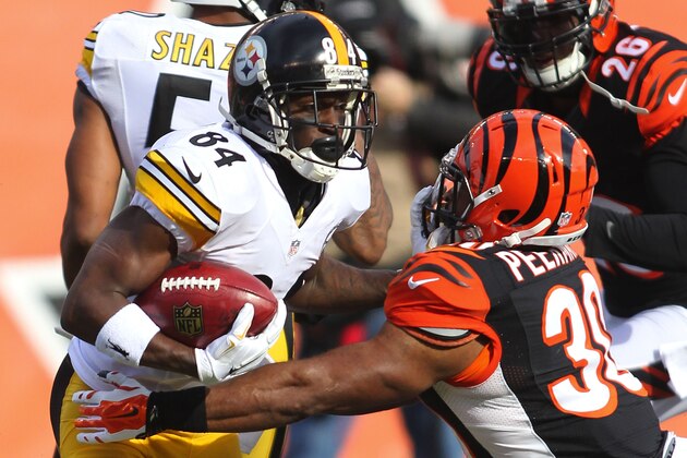 CINCINNATI, OH - DECEMBER 7:  Antonio Brown #84 of the Pittsburgh Steelers breaks a tackle by Cedric Peerman #30 of the Cincinnati Bengals during the first quarter at Paul Brown Stadium on December 7, 2014 in Cincinnati, Ohio. (Photo by John Grieshop/Getty Images)