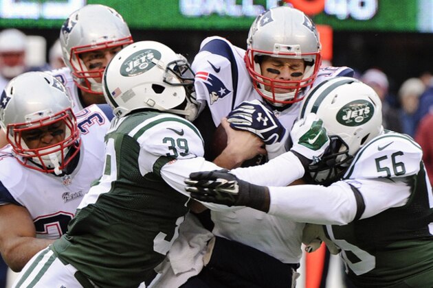 New York Jets cornerback Antonio Allen (39) and Demario Davis (56) sack New England Patriots' Tom Brady, second from right, during the first half of an NFL football game Sunday, Dec. 21, 2014, in East Rutherford, N.J. (AP Photo/Bill Kostroun)