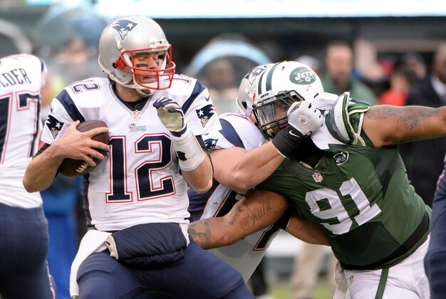 Dec 21, 2014; East Rutherford, NJ, USA; New England Patriots quarterback Tom Brady (12) is sacked by New York Jets defensive end Sheldon Richardson (91) in the first half during the game at MetLife Stadium. Mandatory Credit: Robert Deutsch-USA TODAY Sports