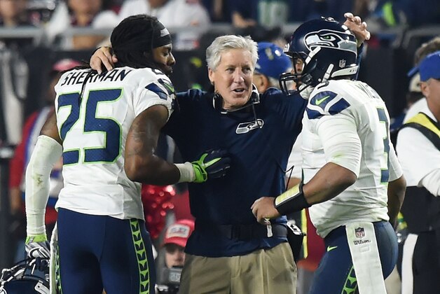 GLENDALE, AZ - DECEMBER 21:  Head coach Pete Carroll of the Seattle Seahawks congratulates cornerback Richard Sherman #25 and quarterback Russell Wilson #3 after they scored the final touchdown of the game in the fourth quarter against the Arizona Cardinals at University of Phoenix Stadium on December 21, 2014 in Glendale, Arizona. The Seahawks won 35-6. (Photo by Norm Hall/Getty Images)