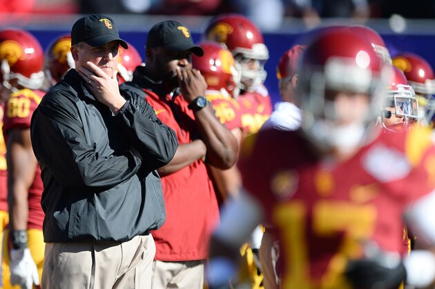 LAS VEGAS, NV - DECEMBER 21:  USC Trojans interim coach Clay Helton (L) watches his team warm up before playing the Fresno State Bulldogs in the Royal Purple Las Vegas Bowl at Sam Boyd Stadium on December 21, 2013 in Las Vegas, Nevada. USC won 45-20.  (Photo by Ethan Miller/Getty Images)