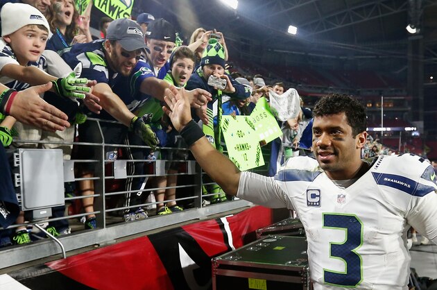 GLENDALE, AZ - DECEMBER 21:  Quarterback Russell Wilson #3 of the Seattle Seahawks celebrates with fans after defeating the Arizona Cardinals 35-6 in the NFL game at the University of Phoenix Stadium on December 21, 2014 in Glendale, Arizona.  (Photo by Christian Petersen/Getty Images)