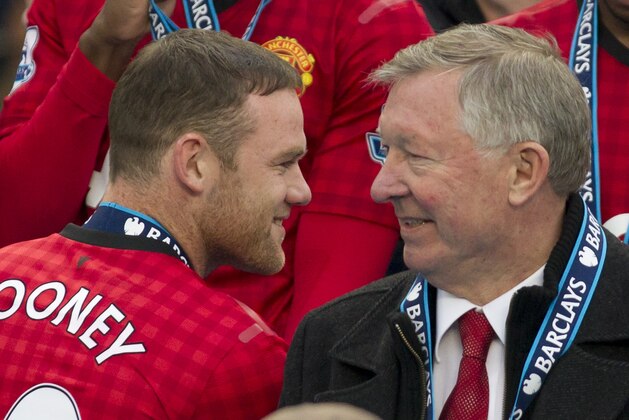 Manchester United's manager Sir Alex Ferguson, right, speaks to striker Wayne Rooney after his last home game in charge of the club, their English Premier League soccer match against Swansea, at Old Trafford Stadium, Manchester, England, Sunday May 12, 2013. (AP Photo/Jon Super)