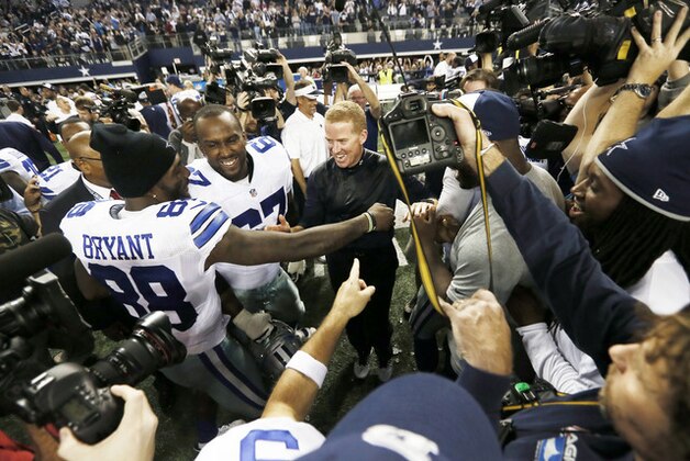 Dallas Cowboys wide receiver Dez Bryant (88) and tackle Tony Hills (67) congratulate head coach Jason Garrett after the second half of an NFL football game against the Indianapolis Colts, Sunday, Dec. 21, 2014, in Arlington, Texas. The Cowboys won 42-7. (AP Photo/Brandon Wade)
