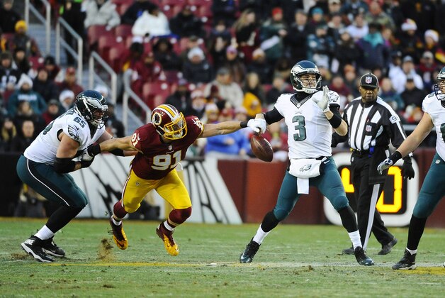 Dec 20, 2014; Landover, MD, USA; Philadelphia Eagles quarterback Mark Sanchez (3) fumbles the ball after a hit by Washington Redskins outside linebacker Ryan Kerrigan (91) during the first half at FedEx Field. Mandatory Credit: Brad Mills-USA TODAY Sports