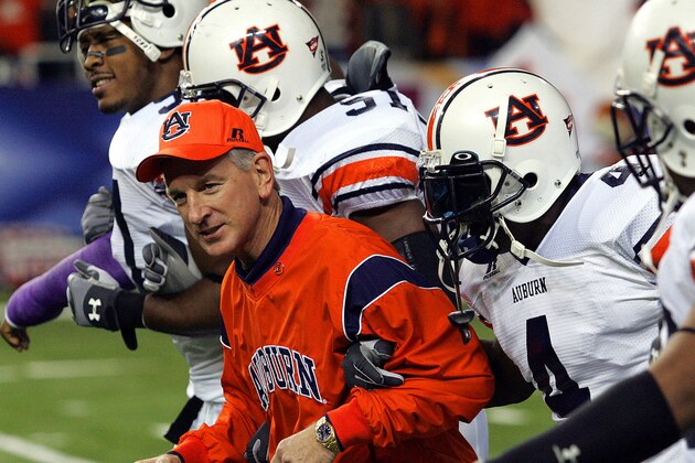 Auburn coach Tommy Tuberville links arms with his players as the prance onto the field prior to the Southeastern Conference football championship game against Tennessee at the Georgia Dome in Atlanta on Saturday, Dec. 4, 2004. Players from left: Mayo Sowell (57), Travis Williams (51) and Junior Rosegreen.  (AP Photo/Ric Feld)