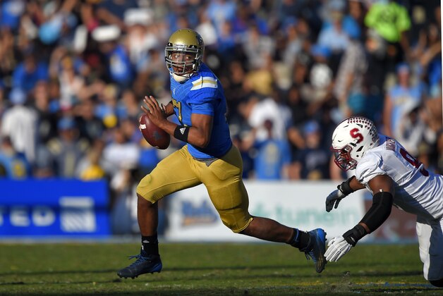 UCLA quarterback Brett Hundley, left, escapes a tackle by Stanford linebacker James Vaughters during the second half of an NCAA college football game, Friday, Nov. 28, 2014, in Pasadena, Calif. Stanford won 31-10. (AP Photo/Mark J. Terrill)