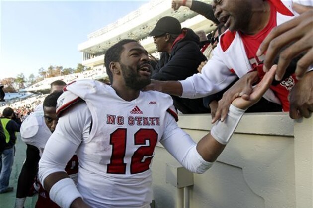 North Carolina State quarterback Jacoby Brissett celebrates with fans following North Carolina State's 35-7 win over North Carolina in an NCAA college football game in Chapel Hill, N.C., Saturday, Nov. 29, 2014. (AP Photo/Gerry Broome)