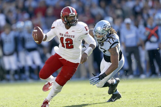 North Carolina's Dajaun Drennon (17) chases North Carolina State quarterback Jacoby Brissett during the first half of an NCAA college football game in Chapel Hill, N.C., Saturday, Nov. 29, 2014. (AP Photo/Gerry Broome)