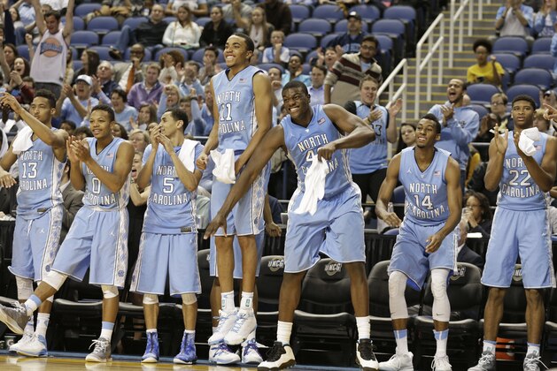 North Carolina players, from left, J.P. Tokoto, Nate Britt, Marcus Paige, Brice Johnson, Joel James, Desmond Hubert and Isaiah Hicks react after a teammate's basket against UNC Greensboro during the second half of an NCAA college basketball game in Greensboro, N.C., Tuesday, Dec. 16, 2014. North Carolina won 79-56. (AP Photo/Chuck Burton)