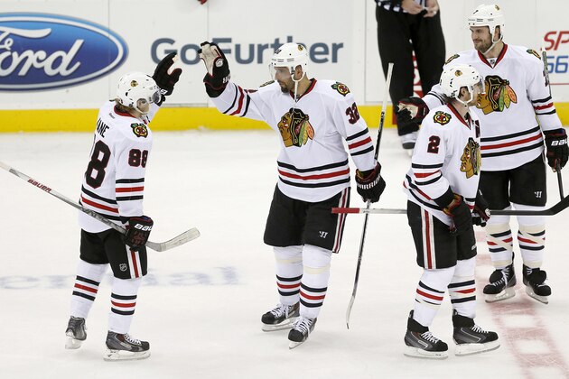 Chicago Blackhawks right wing Patrick Kane (88) is congratulated by Michal Rozsival (32), of the Czech Republic, after the Blackhawks beat the New Jersey Devils 3-2 during a shootout in an NHL hockey game, Tuesday, Dec. 9, 2014, in Newark, N.J. (AP Photo/Julio Cortez)