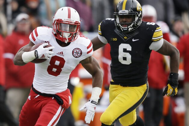 Nebraska running back Ameer Abdullah (8) runs from Iowa linebacker Reggie Spearman during the second half of an NCAA college football game, Friday, Nov. 28, 2014, in Iowa City, Iowa. Nebraska won 37-34 in overtime. (AP Photo/Charlie Neibergall)