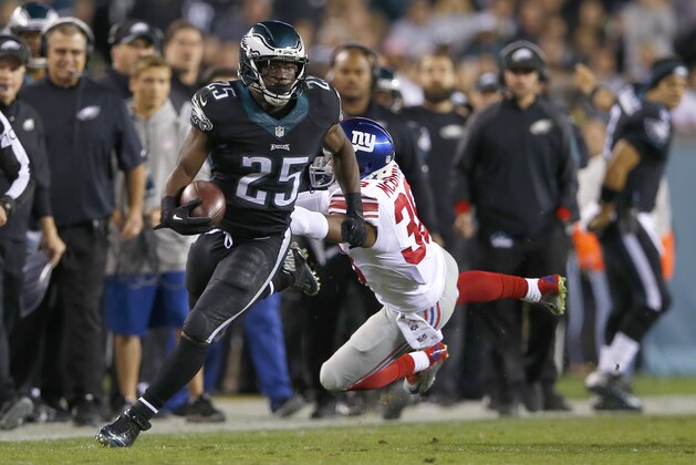 Philadelphia Eagles running back LeSean McCoy (25) avoids a tackle by New York Giants cornerback Trumaine McBride (38) during the first half of an NFL football game, Sunday, Oct. 12, 2014, in Philadelphia. (AP Photo/Michael Perez)