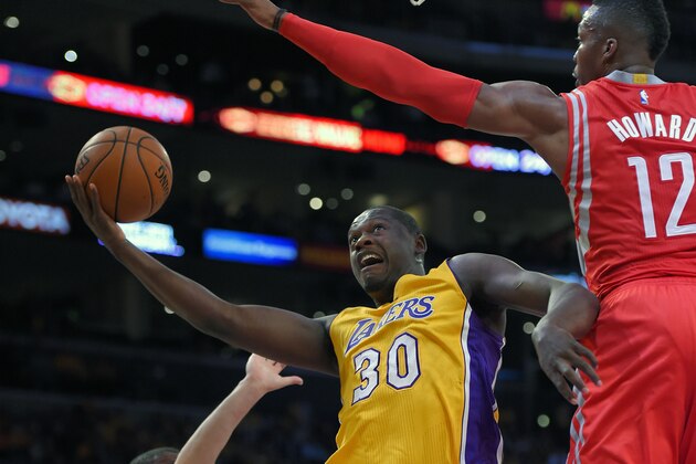 Los Angeles Lakers forward Julius Randle, left, puts up a shot as Houston Rockets center Dwight Howard defends during the first half of an NBA basketball game, Tuesday, Oct. 28, 2014, in Los Angeles. (AP Photo/Mark J. Terrill)