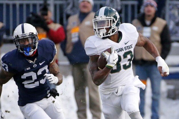 Michigan State running back Jeremy Langford (33) gets around Penn State cornerback Jordan Lucas (23) for a first down during the first half of an NCAA college football game against Penn State in State College, Pa., Saturday, Nov. 29, 2014. (AP Photo/Gene J. Puskar)