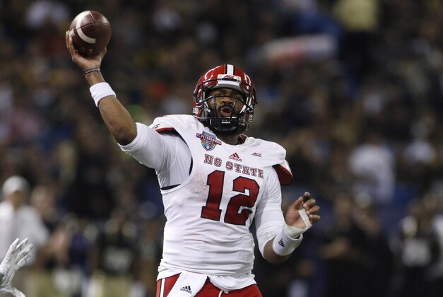 Dec 26, 2014; St. Petersburg, FL, USA; North Carolina State Wolfpack quarterback Jacoby Brissett (12) passes the ball against  the Central Florida Knights during the first half in the 2014 St. Petersburg Bowl at Tropicana Field. Mandatory Credit: Mark Zerof-USA TODAY Sports