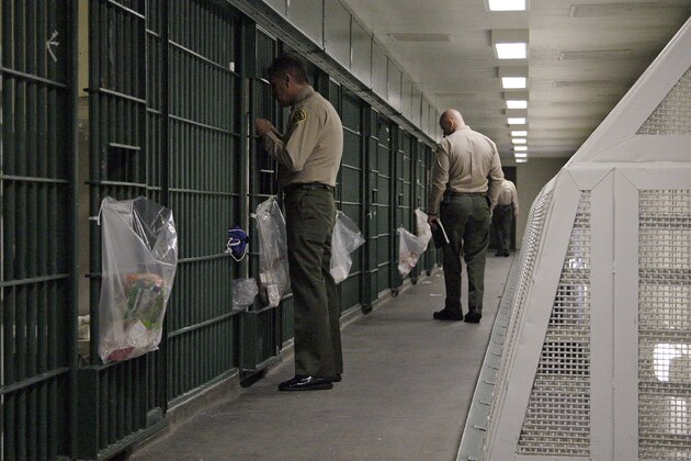 FILE - In this Oct. 3, 2012, file photo, Los Angeles County Sheriff's deputies inspect a cell block at the Men's Central Jail in downtown Los Angeles. The nation’s largest sheriff’s department agreed to federal court oversight and will adopt a new use-of-force policy to settle a class-action lawsuit brought by jail inmates who said they were beaten by guards. The agreement, in effect a consent decree, was approved Tuesday, Dec. 16, 2014, by the Los Angeles County Board of Supervisors. It is the latest in several efforts to reform the scandal-plagued department beset with allegations of rampant abuse by deputies, costly lawsuits and federal convictions of deputies for obstructing an FBI probe into jail beatings. (AP Photo/Reed Saxon, File) FILE - In this Oct. 3, 2012, file photo, Los Angeles County Sheriff's deputies inspect a cell block at the Men's Central Jail in downtown Los Angeles. The nation’s largest sheriff’s department agreed to federal court oversight and will adopt a new use-of-force policy to settle a class-action lawsuit brought by jail inmates who said they were beaten by guards. The agreement, in effect a consent decree, was approved Tuesday, Dec. 16, 2014, by the Los Angeles County Board of Supervisors. It is the latest in several efforts to reform the scandal-plagued department beset with allegations of rampant abuse by deputies, costly lawsuits and federal convictions of deputies for obstructing an FBI probe into jail beatings. (AP Photo/Reed Saxon, File)