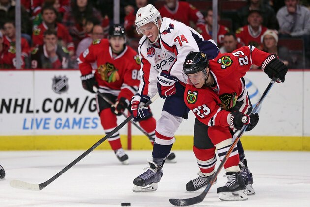 CHICAGO, IL - NOVEMBER 07:  Kris Versteeg #23 of the Chicago Blackhawks tries to get off a shot under pressure from John Carlson #74 of the Washington Capitals at the United Center on November 7, 2014 in Chicago, Illinois. The Capitals defeated the Blackhawks 3-2.  (Photo by Jonathan Daniel/Getty Images)