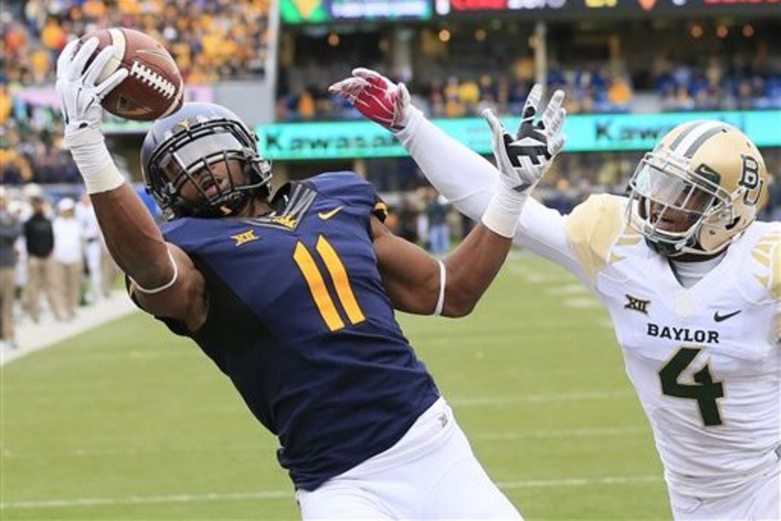 West Virginia's Kevin White (11) catches a pass for a touchdown over Baylor's Xavien Howard (4) in the fourth quarter of an NCAA college football game in Morgantown, W.Va., Saturday, Oct. 18, 2014. (AP Photo/Chris Jackson)