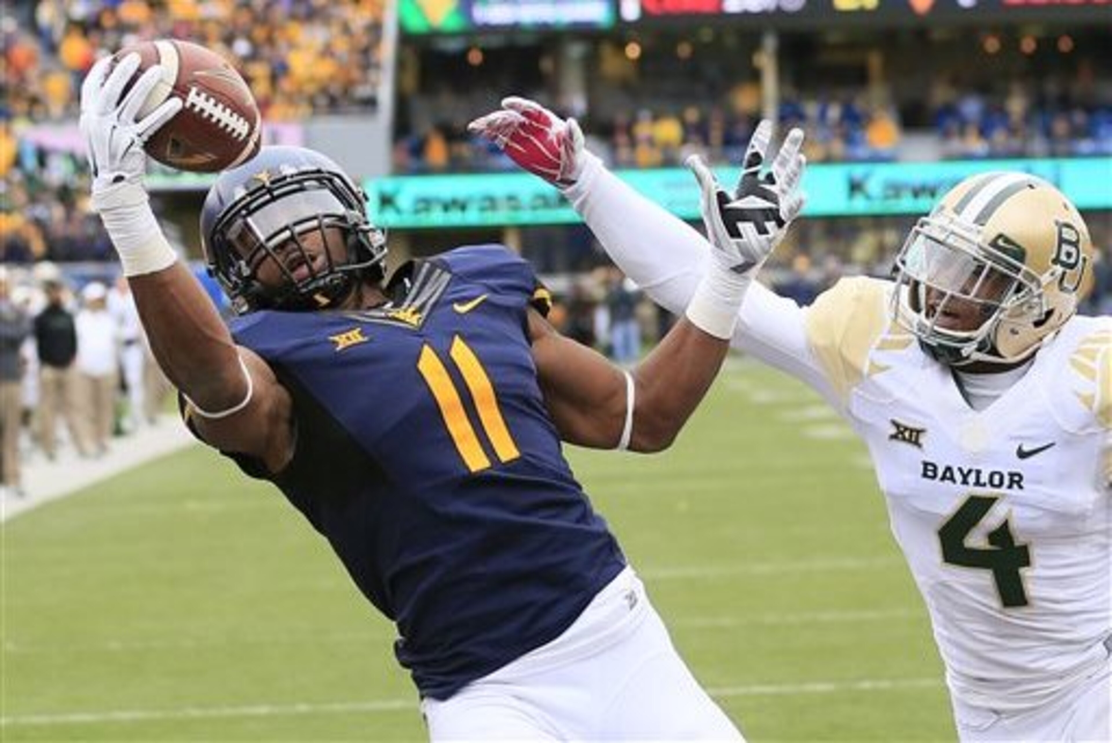 West Virginia's Kevin White (11) catches a pass for a touchdown over Baylor's Xavien Howard (4) in the fourth quarter of an NCAA college football game in Morgantown, W.Va., Saturday, Oct. 18, 2014. (AP Photo/Chris Jackson)