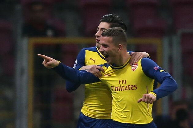 Arsenal's Lukas Podolski, right, celebrates after he scored during their Champions League Group D soccer match with Galatasaray at the Turk Telekom Arena Stadium in Istanbul, Turkey, Tuesday, Dec. 9, 2014.(AP Photo/Emrah Gurel)